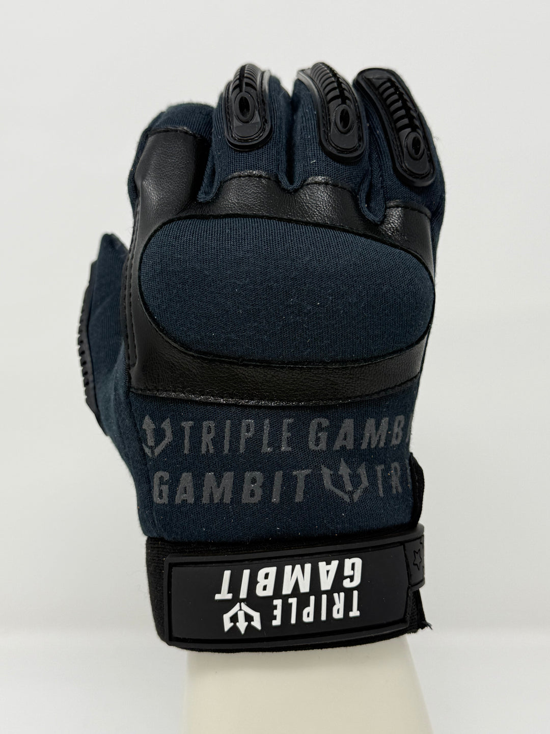 Black tactical glove with 'Triple Gambit' branding on a white background
